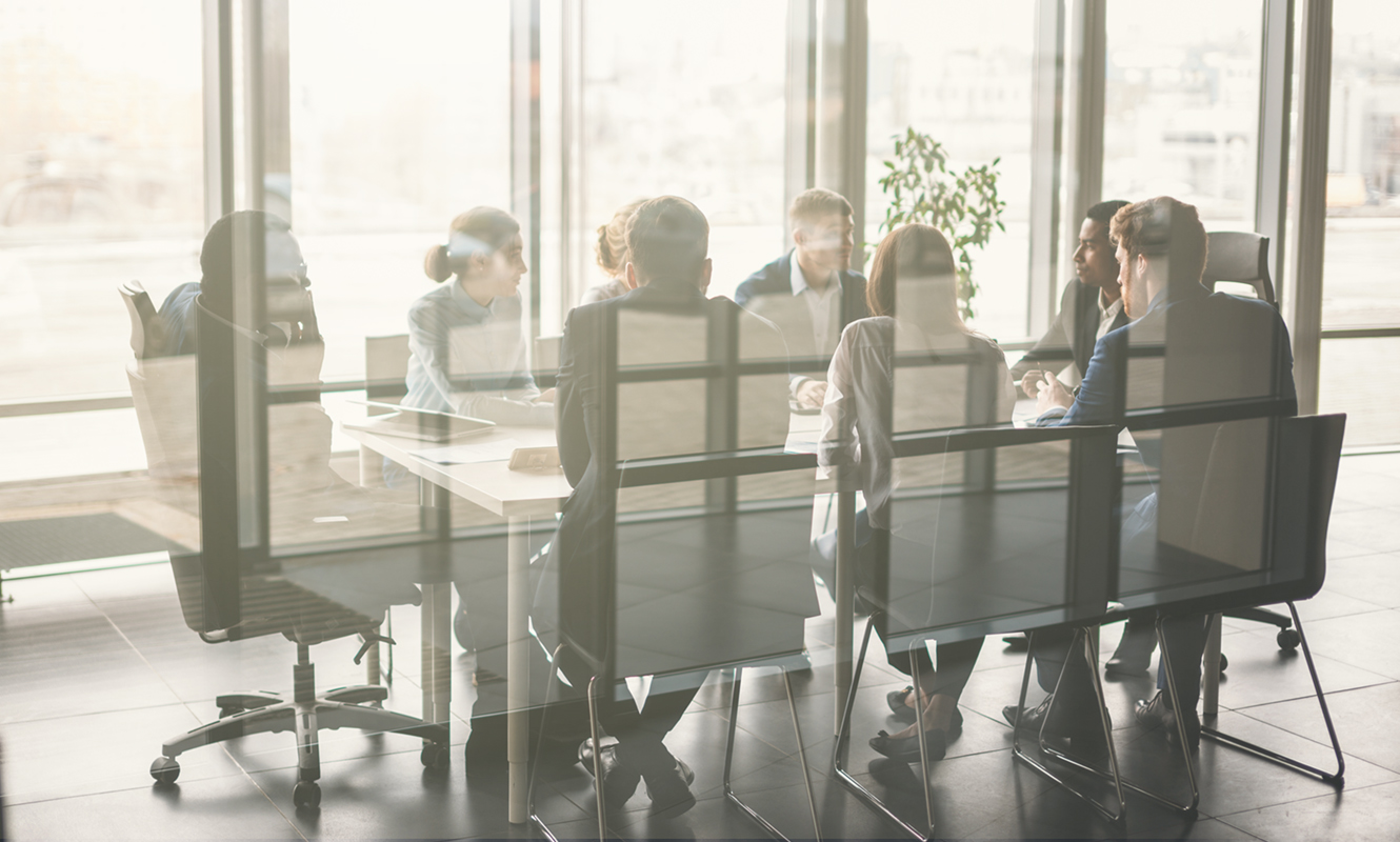 People sitting in a board room having a meeting.